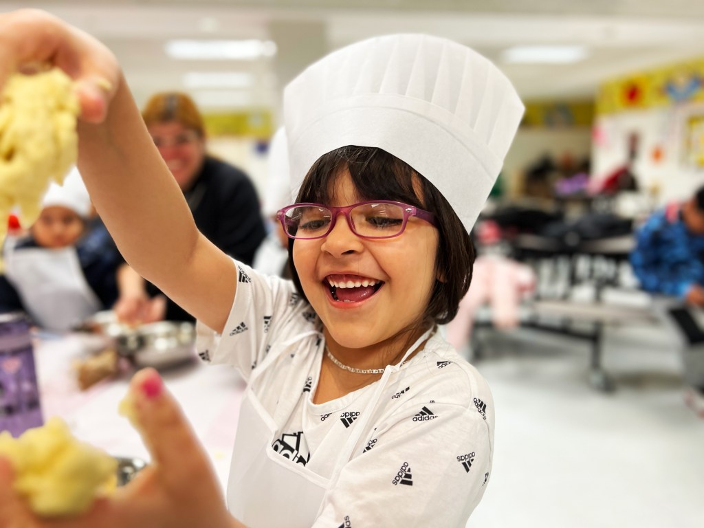 joyful kid in chefs hat